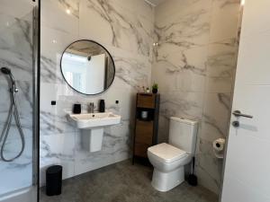 a bathroom with a sink and a toilet and a mirror at Seaview Three-O-Two in St. Paul's Bay