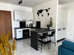 a kitchen with a black island with a world map on the wall at Seaview Three-O-Two in St. Paul's Bay +3 photos