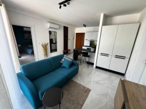 a living room with a blue couch and a kitchen at Seaview Three-O-Two in St. Paul's Bay