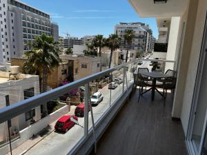 a balcony with a table and a view of a city at Seaview Three-O-Two in St. Paul's Bay