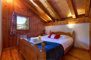 sypialnia z łóżkiem w pokoju z drewnianymi ścianami w obiekcie Village des Oursons Chalet B - Happy Rentals w Chamonix-Mont-Blanc