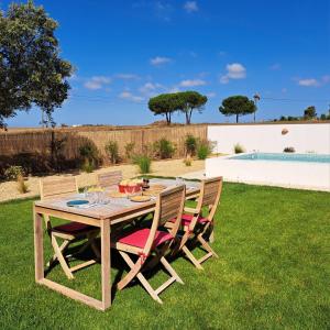 a wooden table and chairs sitting on the grass at Casa dos Foros in Odemira +35 photos