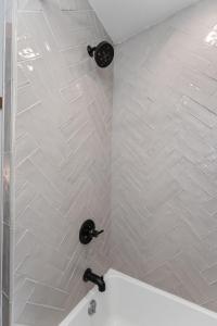 a shower with black fixtures in a bathroom at The Wagen Haus, fireplace and hot tub! in Fredericksburg +14 photos