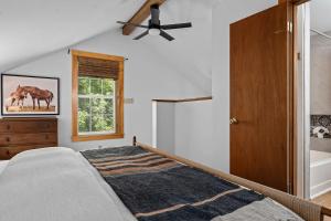 a bedroom with a bed and a ceiling fan at The Wagen Haus, fireplace and hot tub! in Fredericksburg