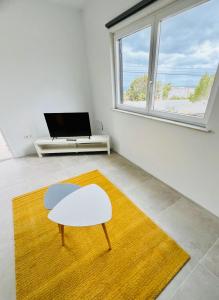 a living room with a table and a yellow rug at Finca PiedraNegra in Tías +48 photos