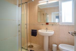 a bathroom with a sink and a glass shower at TrendyHomes City Center in Almería