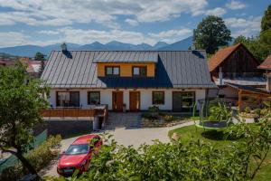 a house with a car parked in front of it at Gazdov dvor in Dolný Kubín