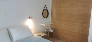une chambre avec un lit et un miroir au mur dans l'établissement Thalassa apartment 2 Perea, à Peraia