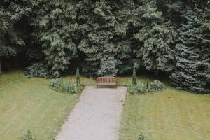 a bench sitting on a path in a park at Ķimales muiža in Ķimale