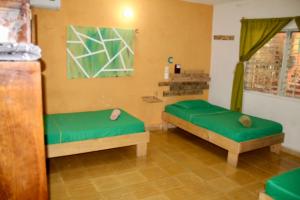 Habitación con 2 camas con cojines verdes en Casa Samay, en Cozumel