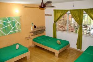 Habitación con 2 camas y ventilador de techo. en Casa Samay, en Cozumel