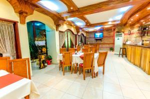 a restaurant with a dining room with tables and chairs at Hotel Cosmos in Asenovgrad