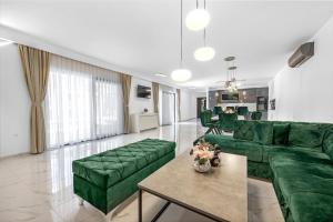 a living room with green couches and a table at Pool House Fancy - Happy Rentals in Labin