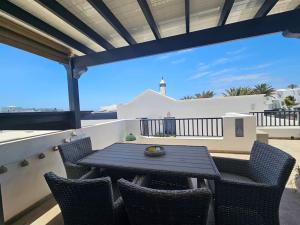 a patio with a table and chairs on a balcony at Luna Azul in Playa Blanca