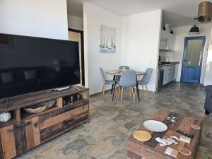 a living room with a large television and a table at Luna Azul in Playa Blanca