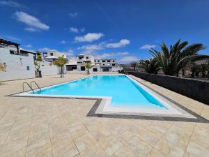 a large swimming pool in a yard with houses at Luna Azul in Playa Blanca