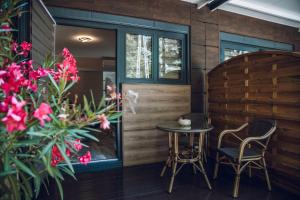 a patio with a table and two chairs and flowers at Villa Apartman in Makó
