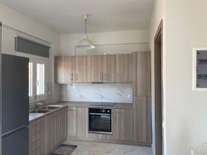 a kitchen with wooden cabinets and a sink at Eagle View Karystos in Karistos