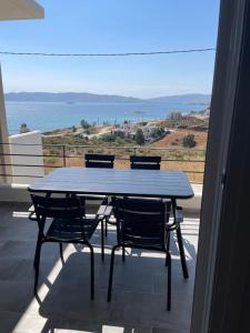 a table and chairs on a balcony with a view of the ocean at Eagle View Karystos in Karistos