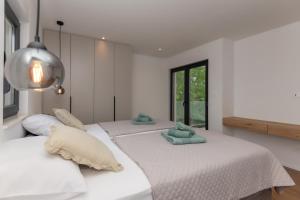 KasaliにあるVilla Amnis Imotski Makarskaのタオルが敷かれた白い部屋にベッドが2つある +34枚の写真
