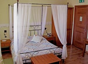 a bedroom with a canopy bed with white curtains at Hotel La Fontana in Trieste