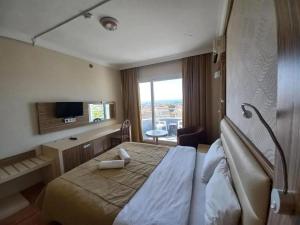 a hotel room with a large bed and a window at Moonstar Hotel in Kusadası