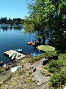 a table with an umbrella next to a lake at Guppies Lakehouse-Prvt. Lake Acc, Close to Rainier in Graham