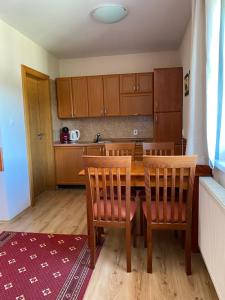 a kitchen with a wooden table and two chairs at Apartmán Dorian in Bešeňová