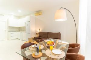 a living room with a dining table and chairs at TrendyHomes City Center in Almería +69 photos