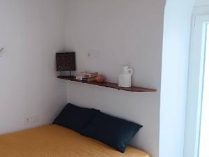 ein Schlafzimmer mit einem Bett und einem Regal an der Wand in der Unterkunft Little House in Káto Petálion