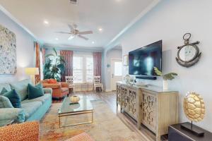 a living room with a couch and a flat screen tv at The Salty Whale in Galveston