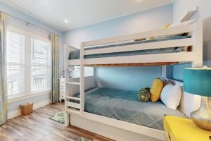 a bedroom with two bunk beds and a desk at The Salty Whale in Galveston