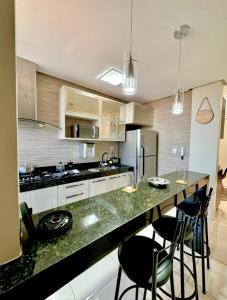 パラカトゥにあるApartamento Lacerdaのキッチン(椅子と冷蔵庫付きのカウンター付)