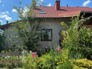 PrzykonaZagroda Olszówka的一栋前面带花园的房子