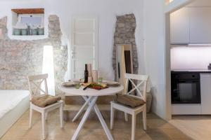a white dining room with a table and chairs at Konzul Apartment in Pula