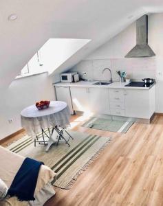 a white kitchen with a table and a sink at Pure Mountain - Serra da Estrela in Erada