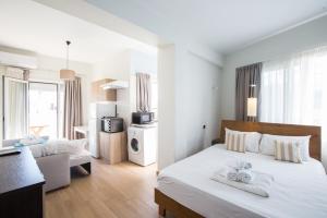 a hotel room with a bed with towels on it at Theo Apartment Rethymno in Rethymno