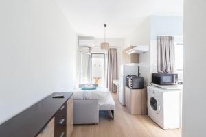 a white room with a bed and a microwave at Theo Apartment Rethymno in Rethymno
