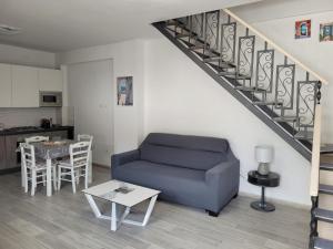 a living room with a blue couch and a table at Cozy Corner Apartment Forio in Forio d'Ischia