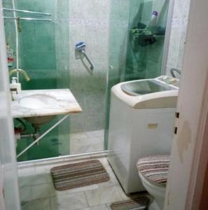 a bathroom with a shower and a sink and a toilet at Quarto Privativo - Pitangueiras - 50mts da Praia in Guarujá