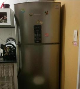 a refrigerator with a cell phone on top of it at Quarto Privativo - Pitangueiras - 50mts da Praia in Guarujá