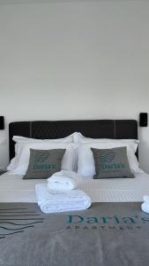 a bed with two pillows and two towels on it at Daria’s Luxury Apartment-the hidden gem in Epanomi