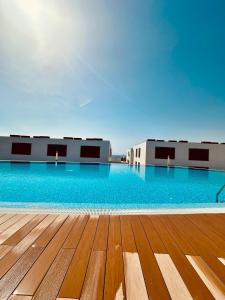 a pool with blue water and a wooden deck at Julia Ancor beach in Abades