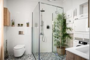 a bathroom with a shower with a toilet and plants at Infinite Residences - Central Location, Tradition and Comfort in Corfu Town +21 photos