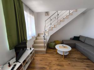 Una sala de estar con un sofá y una escalera. en Sunny Beach Cozy Apartment With a Pool, en Sunny Beach