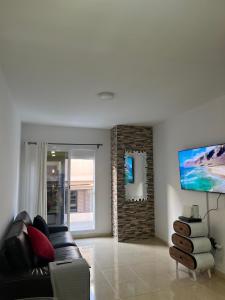 sala de estar con sofá de cuero negro y ventana en Silver House Lanzarote, en Arrecife