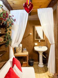 a bathroom with a bed and a sink with a heart balloon at Posada El Palomar in Pátzcuaro +118 photos