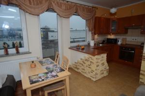 a kitchen with a counter and a table and some windows at Apartament Classic in Szczecin