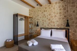 a bedroom with a bed with towels on it at Obsidian Suites Milos in Mytakas +18 photos