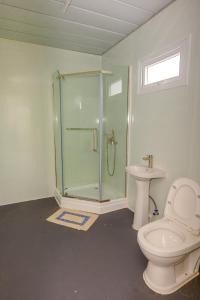 a bathroom with a shower and a toilet and a sink at Shalini Garden Hotel & Apartments in Singatoka